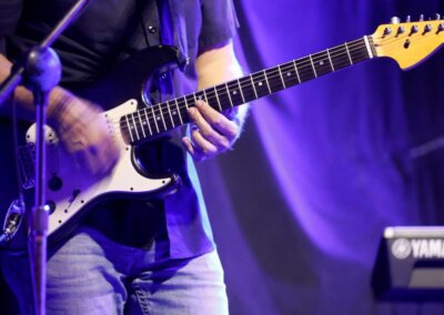 Guitar player, strumming hand is blurred